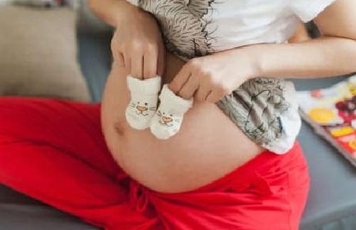 Futur maman avec des chaussons de bébé